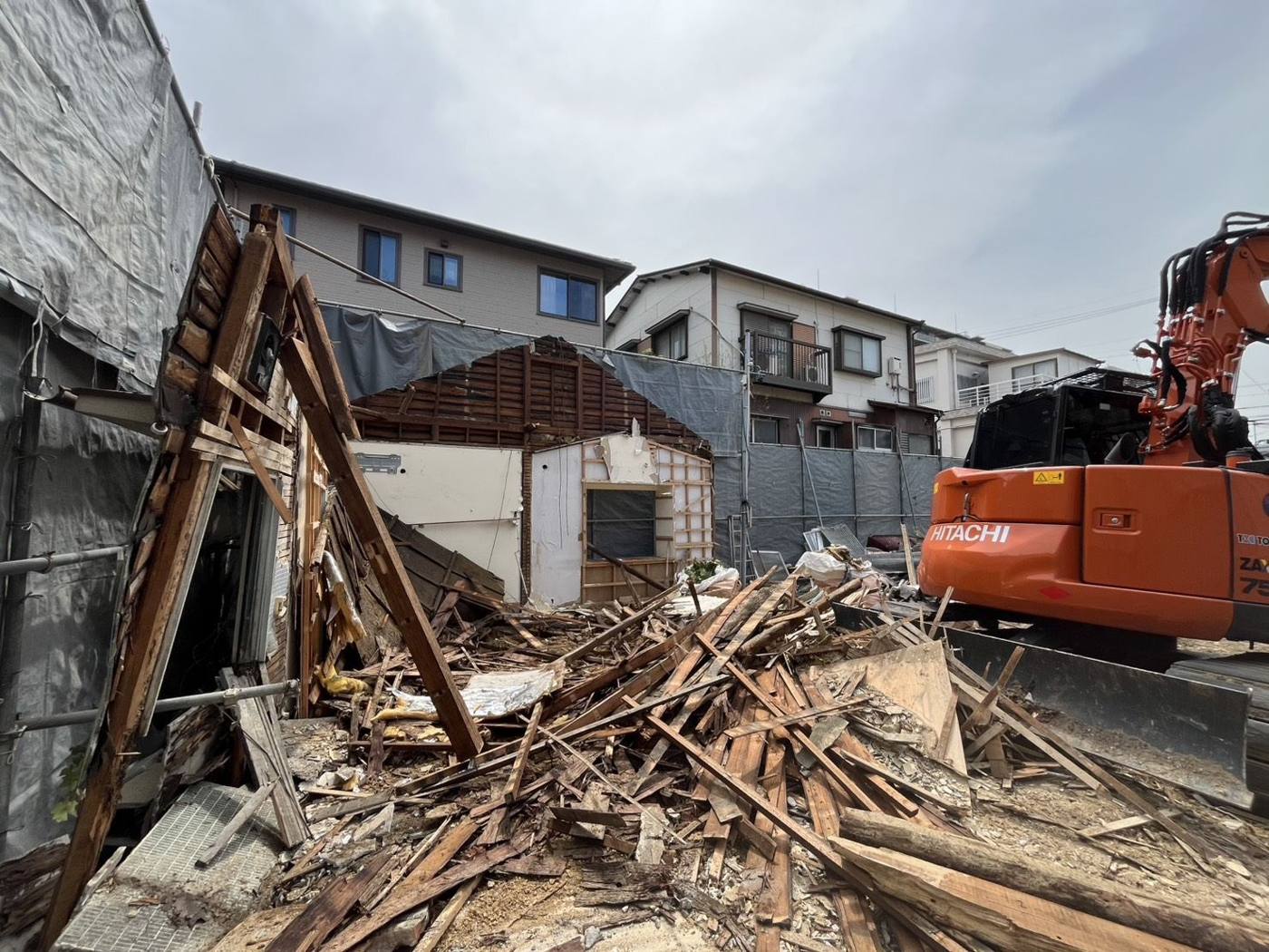 重機で木造住宅を解体している現場